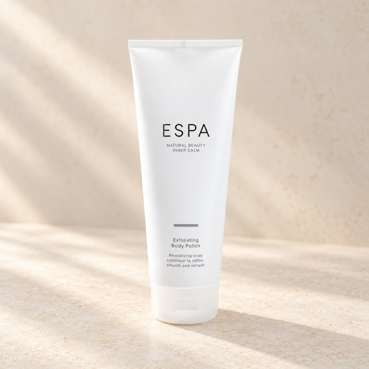 ESPA Exfoliating Body Polish on a pale stone surface (styled image)