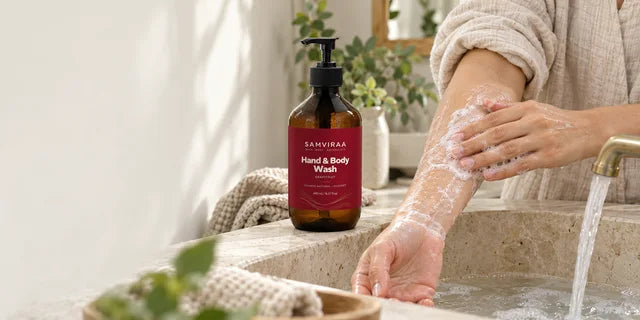 An adult washing their forearm in a basin beside SAMVIRAA Grapefruit Hand & Body Wash.