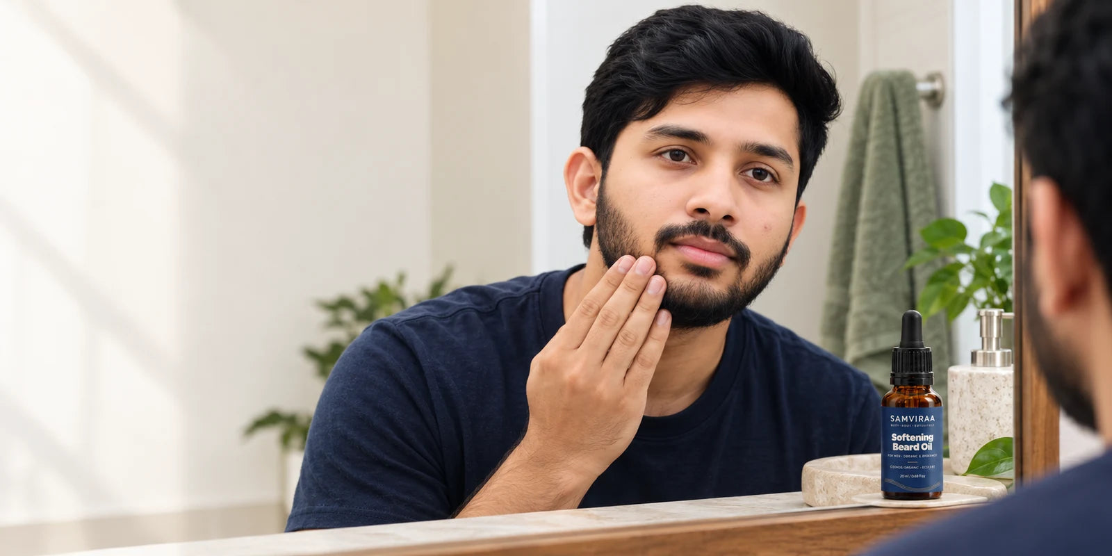 A man applying SAMVIRAA Softening Beard Oil along his jaw.